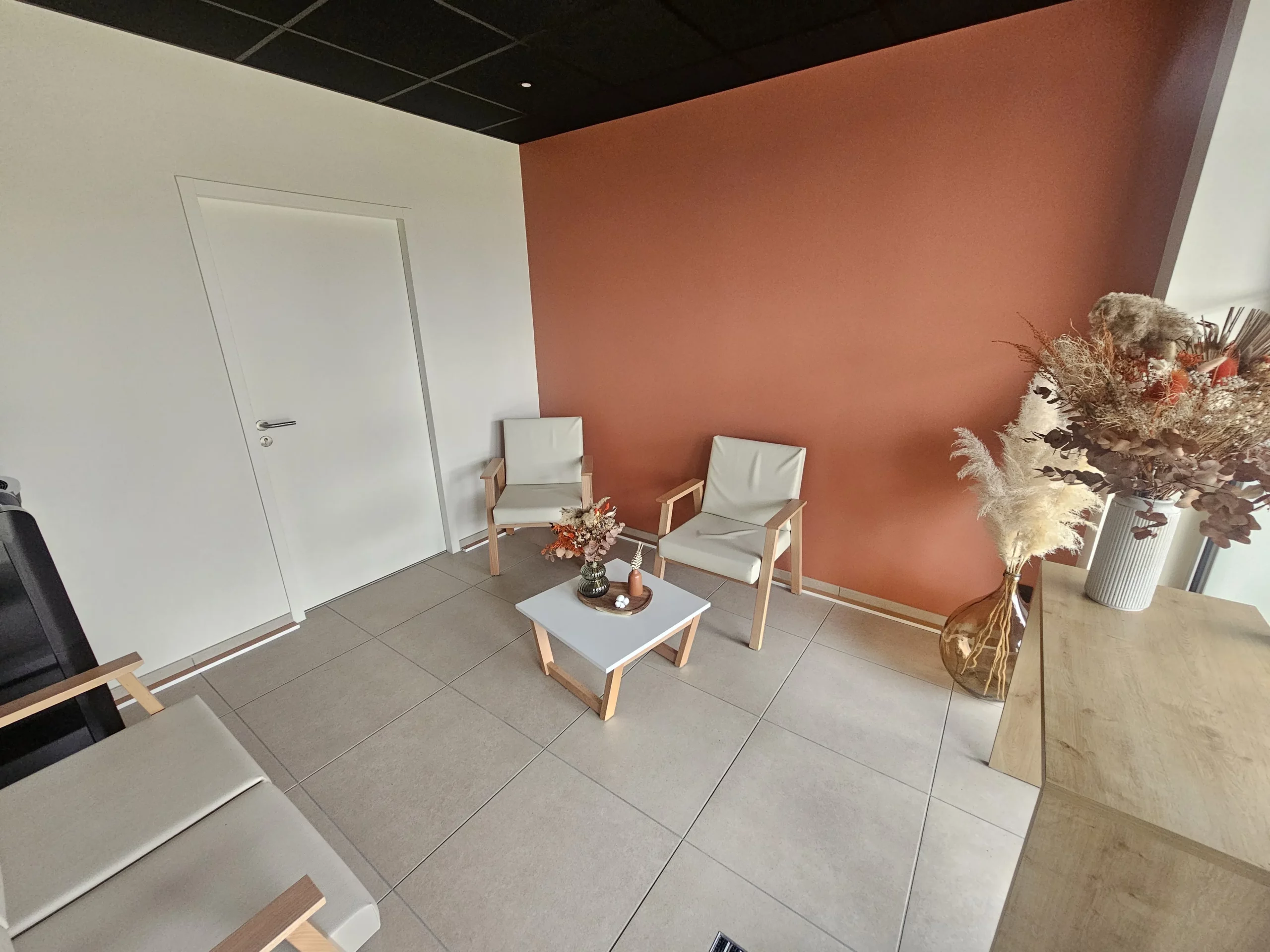 Salon de réception chaleureux et espace de conseil pour l'organisation d'obsèques en agence funéraire