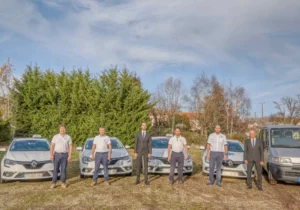 Équipe des Pompes Funèbres Rigal posant devant la flotte de véhicules sanitaires et ambulances